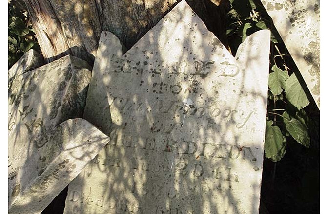 Headstones belonging to the nearly 200-year-old Dixon Family Burial Grounds rest beneath a tree prior to the development of Pioneer Trail Drive.